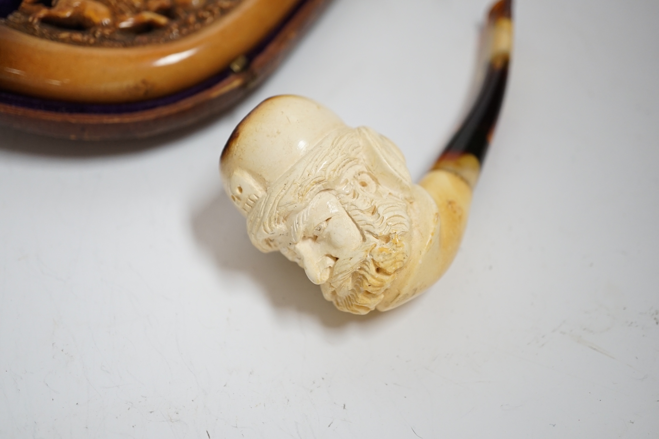 Two carved Meerschaum pipes, one in the form of a huntsman on horseback with amber mouthpiece